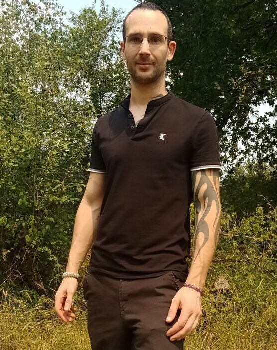 Cédric Grenat debout dans une foret un beau matin.