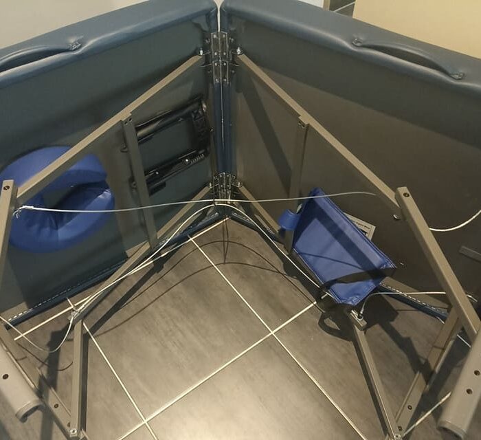 Table de massage haut de gamme et super confortable en train d'être mise en place avec les accessoires à l'intérieur.